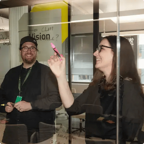 two people standing in front of a glass drawing board-1